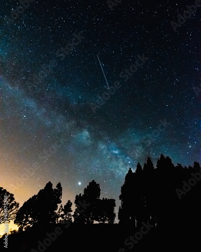 .Night of stars with the milky way, the silhouette of the trees and with the last colors of the sunset