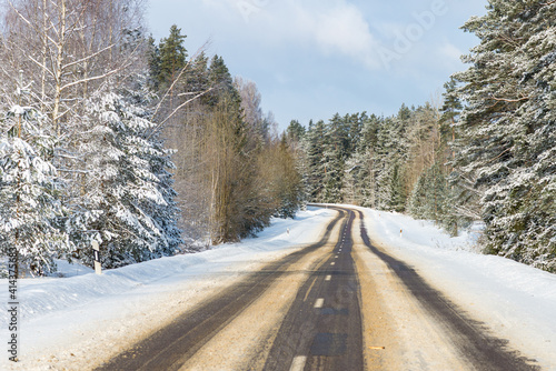 Winter road in snowy forest on a sunny day. © ARVD73