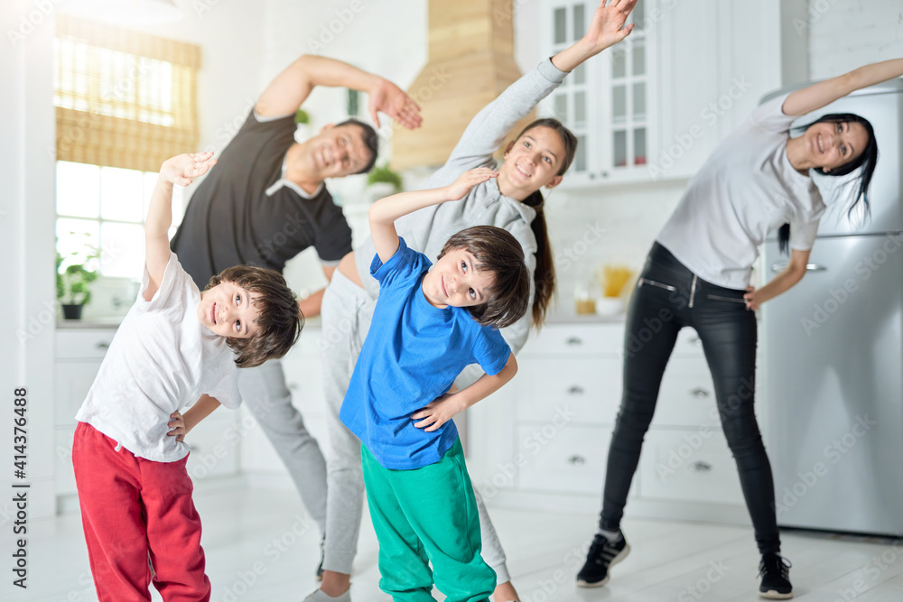 © Friends Stock - It's warming up. Happy latin family exercising, having morning workout together at home © Friends Stock - It's warming up. Happy latin family exercising, having morning workout together at home