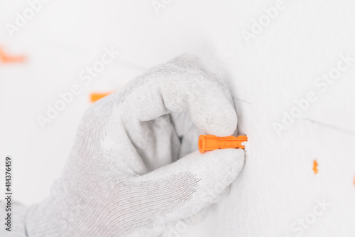 Foto hand inserts an anchor plug into a concrete wall