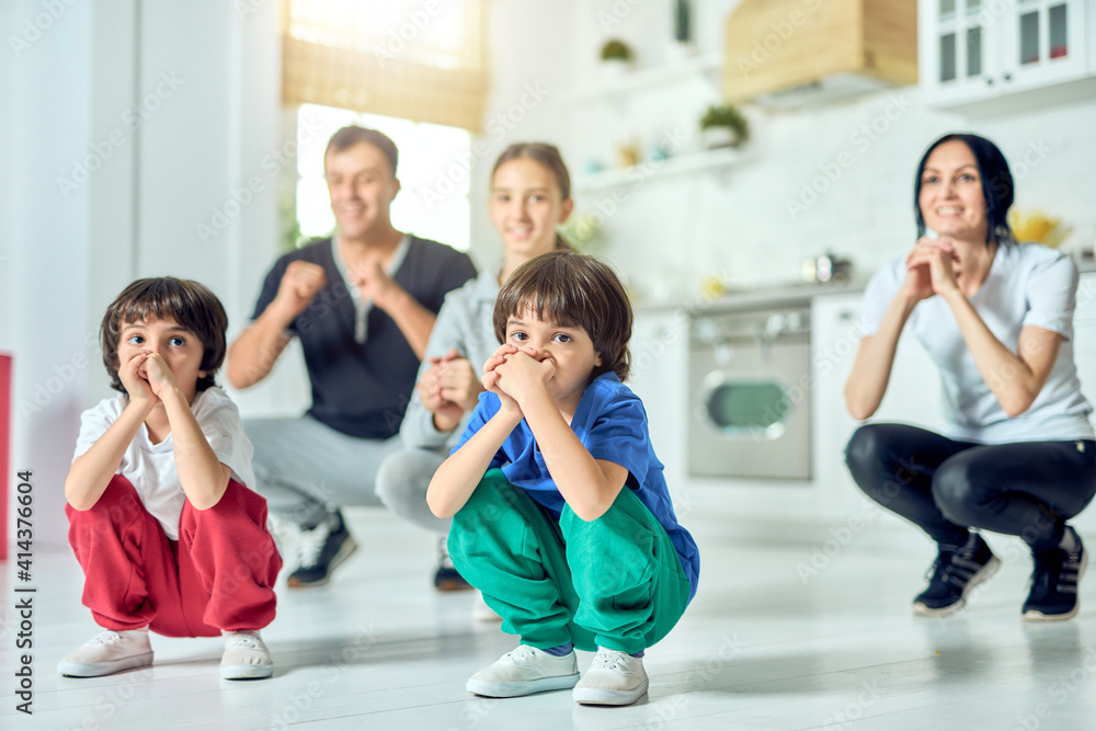 Stay fit. Cute little latin boys working out together with their parents and sister at home Stay fit. Cute little latin boys working out together with their parents and sister at home