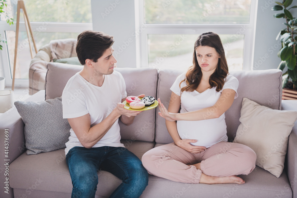Photo of cute funny couple expecting child mom sitting couch embracing belly not want eat disgusting food inside indoors Photo of cute funny couple expecting child mom sitting couch embracing belly not want eat disgusting food inside indoors