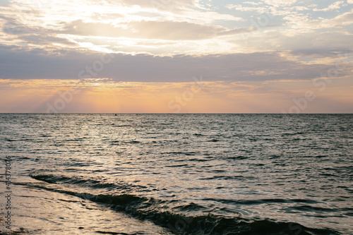 Sunset by the sea. Warm colors. There are no people. The photo is horizontal  color.