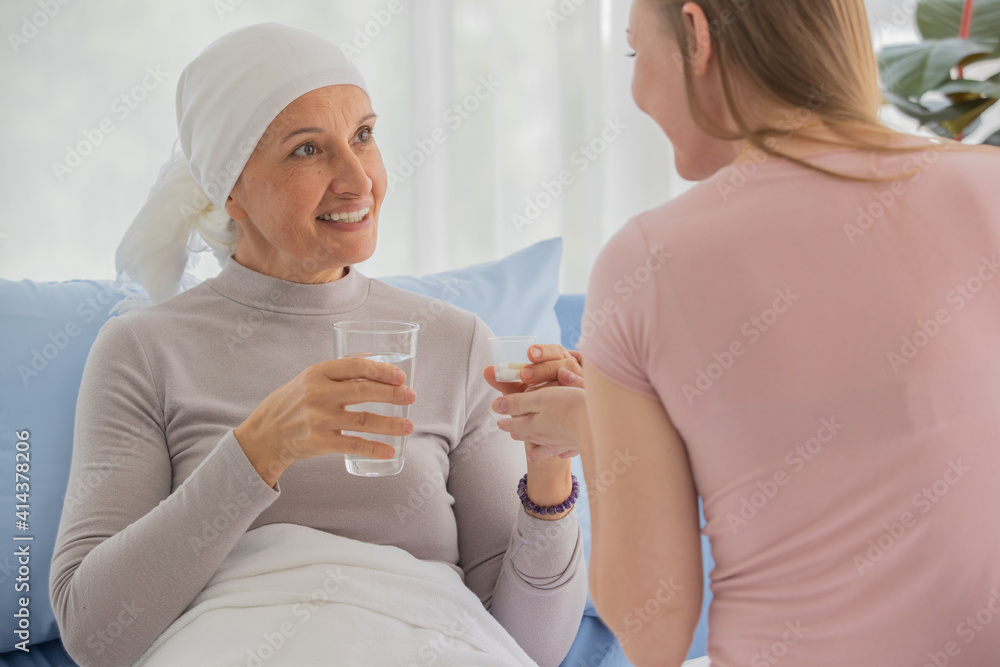 Daughter take medicine and glass of water to bring to female cancer patient who lay on the bed for love and take care and encourage with concern and relationship Daughter take medicine and glass of water to bring to female cancer patient who lay on the bed for love and take care and encourage with concern and relationship