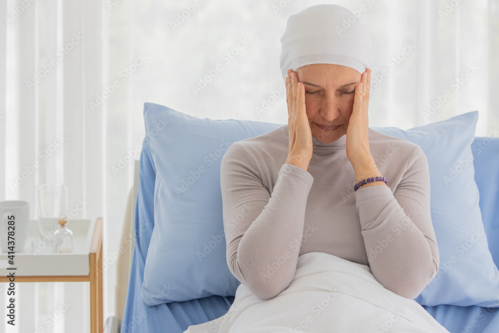 Middle-aged breast cancer woman feels tired and headache on bed Middle-aged breast cancer woman feels tired and headache on bed