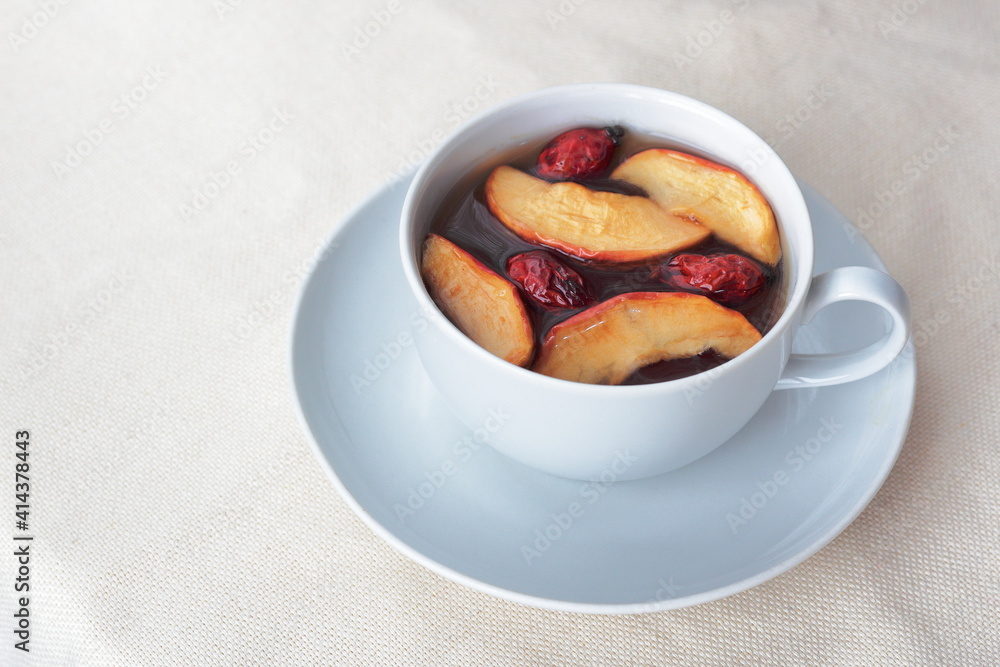 tea with dried apples and rosehip in a white cup
