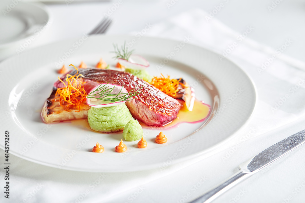 Tender dorado fillet with vegetables and basil. Banquet festive dishes. Gourmet restaurant menu. White background. Tender dorado fillet with vegetables and basil. Banquet festive dishes. Gourmet restaurant menu. White background.