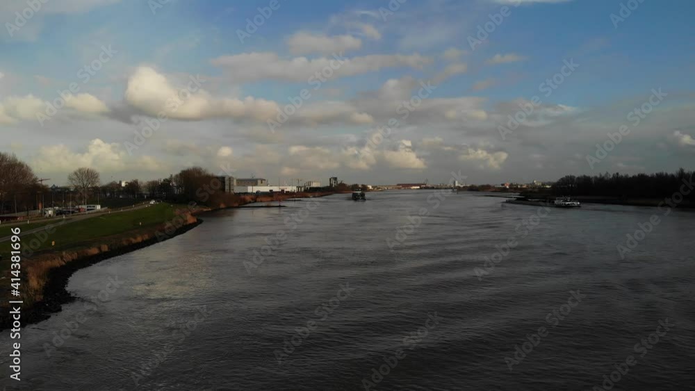 Scenic View With Cargo Vessels Sailing Across Quiet River Of Oude Maas In The City Of Zwijndrecht, Netherland. - Aerial Wide Shot Scenic View With Cargo Vessels Sailing Across Quiet River Of Oude Maas In The City Of Zwijndrecht, Netherland. - Aerial Wide Shot