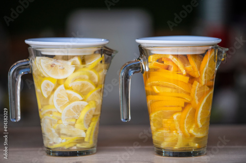 Принти на полотні Two glass Jars with water and fresh fruit, Lemon and Orange, a refreshing and healthy summer drink