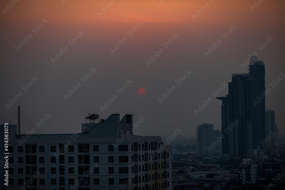 The blurred abstract background of the morning sun exposure to the tiny dust particles that surround the tall buildings in the capital, the long-term health issue of pollution