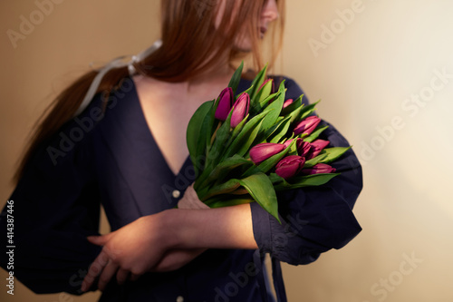 Tulip flowers. Long hair woman holding beautiful spring bouquet of tulips. March 8, Mother's Day or International Woman's Day concept