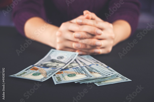 Foto Woman holding and counting cash money american dollars in her hands on black table background