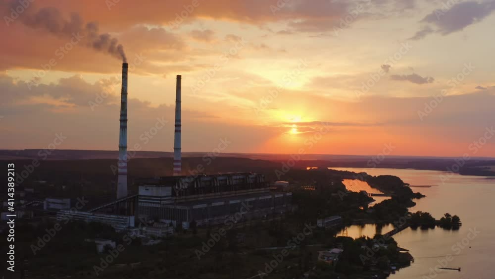 Industrial refinery with smokestack near a river. Amazing sunset at industrial zone. View from above. Video from dron. Industrial refinery with smokestack near a river. Amazing sunset at industrial zone. View from above. Video from dron.