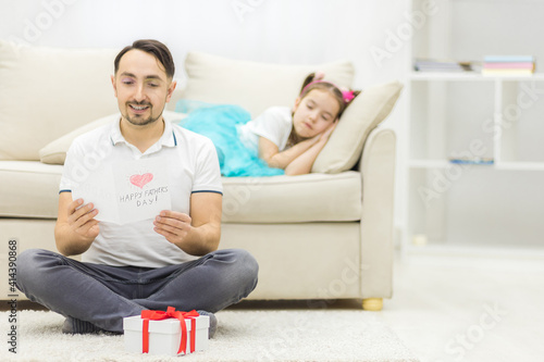 Photo of handsome young man at home with his little cute girl.