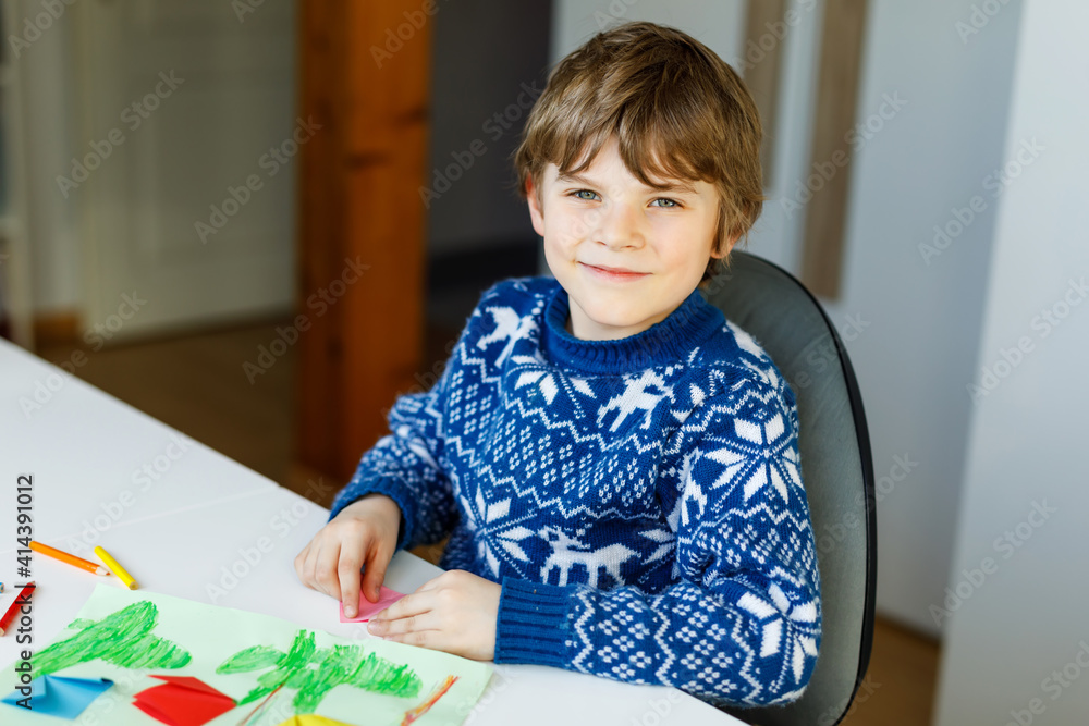 Little kid boy making paper origami tulip flowers for a postcard for mother's day or birthday. Cute child of elementary class school doing handicraft Little kid boy making paper origami tulip flowers for a postcard for mother's day or birthday. Cute child of elementary class school doing handicraft
