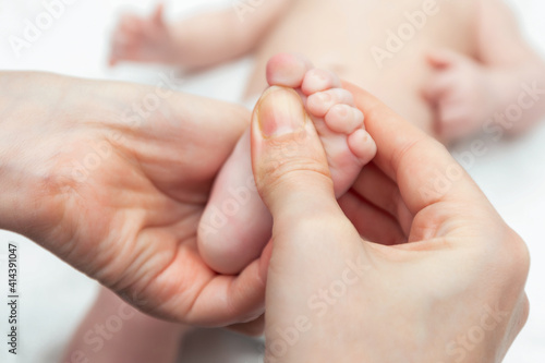 Masseur massaging little baby's foot. Hands of therapist rubs the small leg of infant. Health care concept for child and relax.