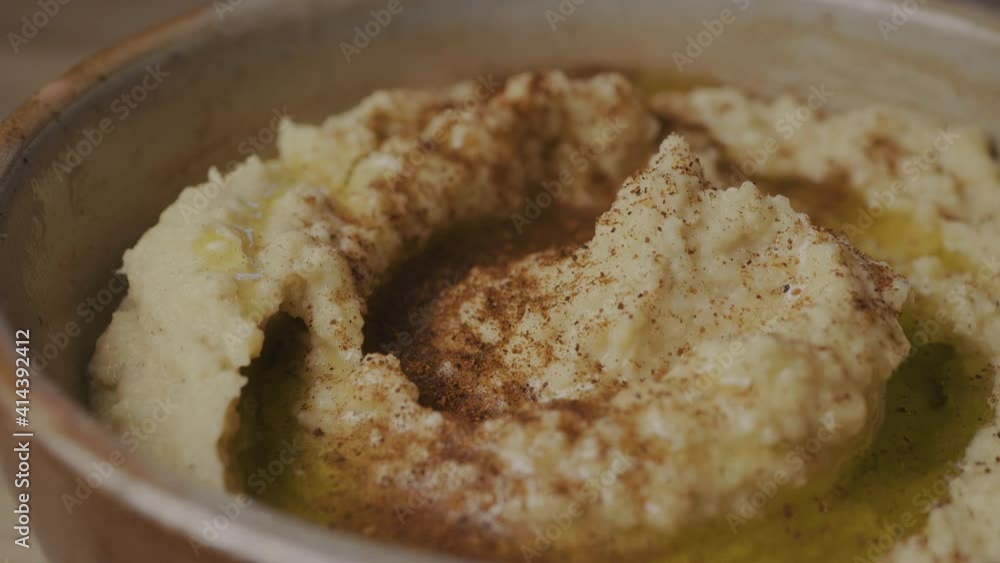 Chili powder over fresh hummus in a bowl Chili powder over fresh hummus in a bowl