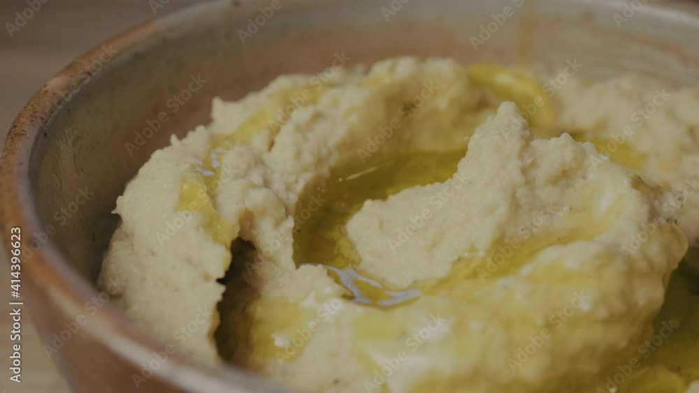 Olive oil over fresh hummus in a bowl Olive oil over fresh hummus in a bowl