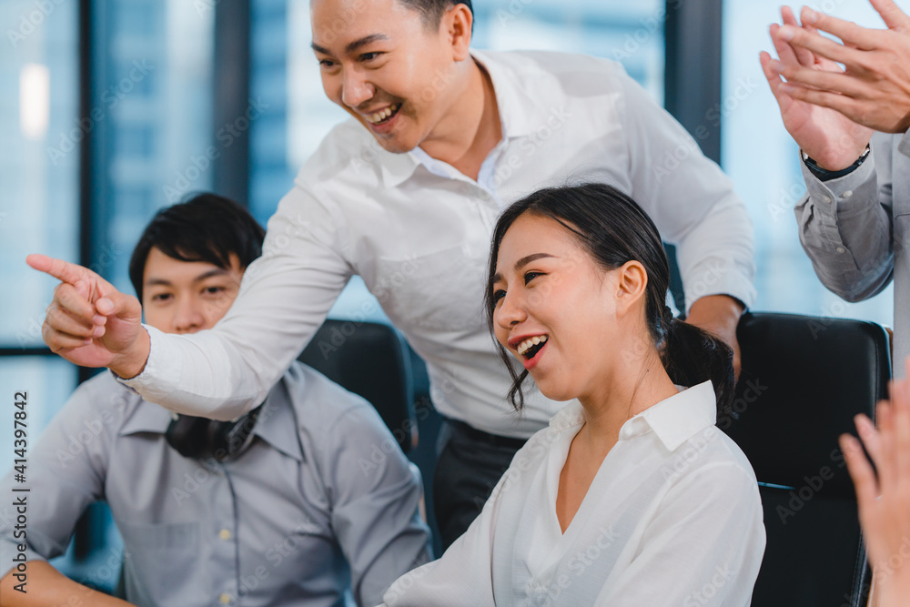 Millennial group of young businesspeople Asia businessman and businesswoman celebrate giving five after dealing feeling happy and signing contract or agreement at meeting room in small modern office. Millennial group of young businesspeople Asia businessman and businesswoman celebrate giving five after dealing feeling happy and signing contract or agreement at meeting room in small modern office.