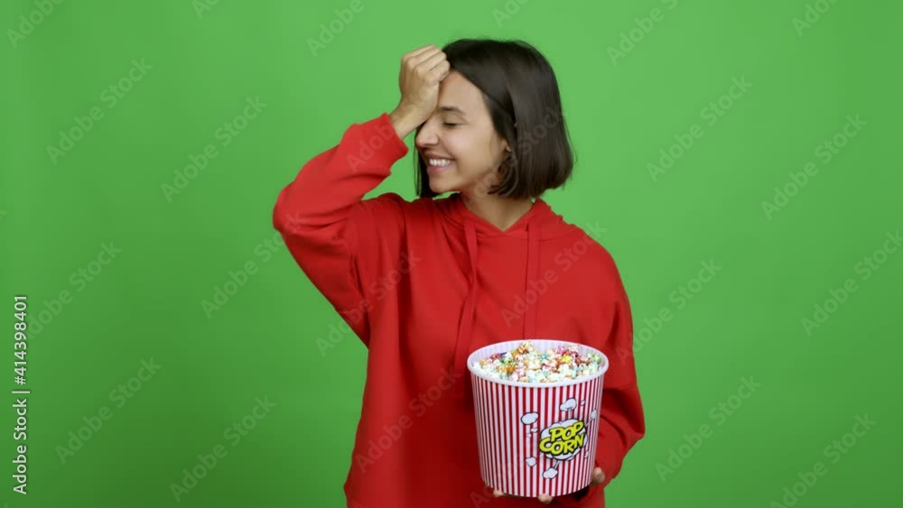 Woman holding a bowl of popcorns intending to realizes the solution while lifting a finger up over isolated background Woman holding a bowl of popcorns intending to realizes the solution while lifting a finger up over isolated background