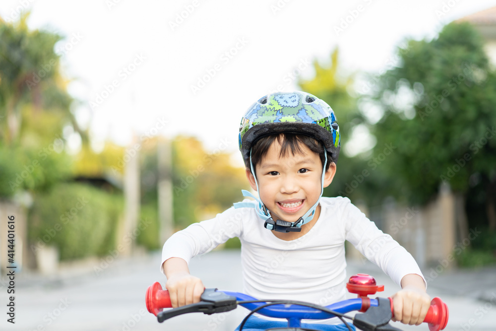 Obraz premium boy is riding bicycle at the park.