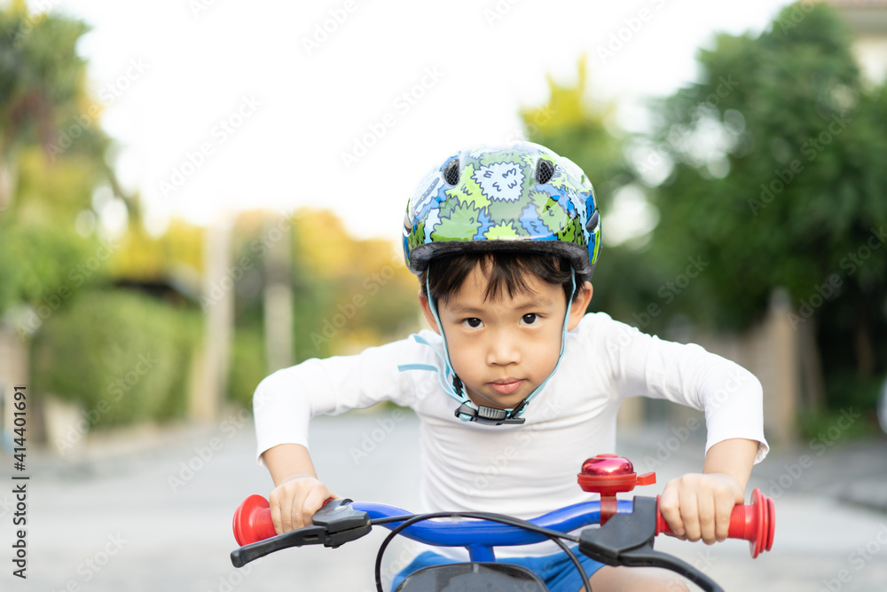 Obraz premium boy is riding bicycle at the park.