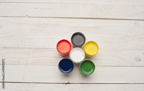 Multicolored paints and notepads on wooden table drawing background image mockup Poster