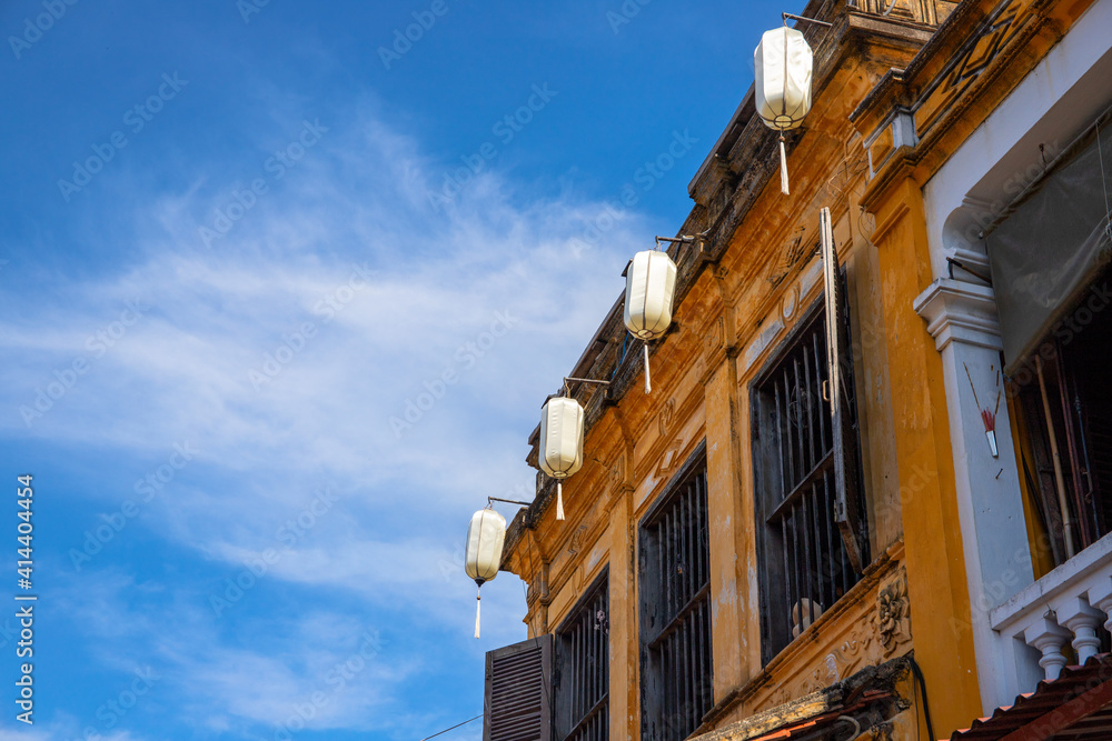 Old building with chinese lanterns, Vietnam architecture detail. Yellow house facade. French colonial house in Hoi An