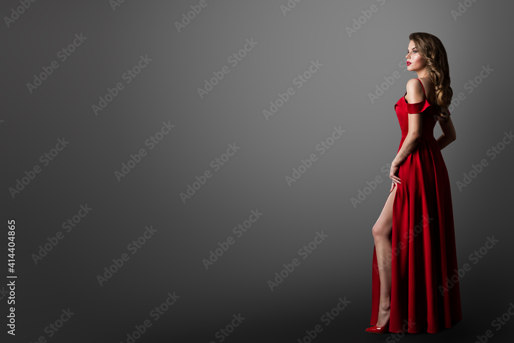 Fashion Woman in Long Red Dress. Model Showing Leg in Evening Silk Slit Gown. Profile View. Black Background with Copy Stock-foto | Adobe Stock