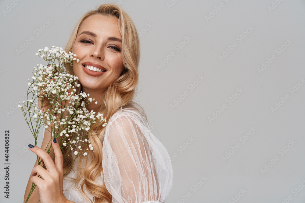 Beautiful happy girl smiling while posing with flowers Beautiful happy girl smiling while posing with flowers