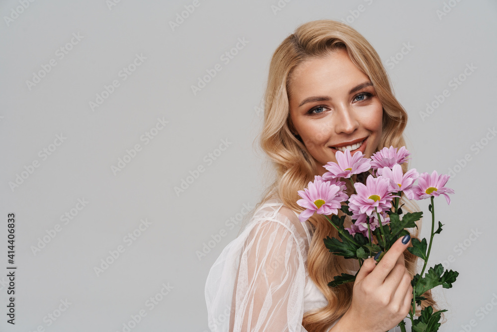 Beautiful happy girl smiling while posing with flowers