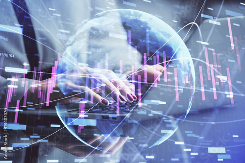 Double exposure of businesswoman hands typing on computer and financial graph hologram drawing. Stock market analysis concept.