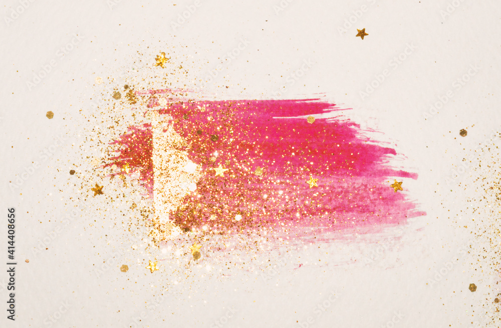 Golden glitter and glittering stars on abstract pink and gold watercolor splash in vintage nostalgic colors on light gray background