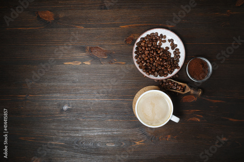 Coffee cup, coffee beans and ground powder on wooden background. Copy space for your text. Top view. Flat lay.
