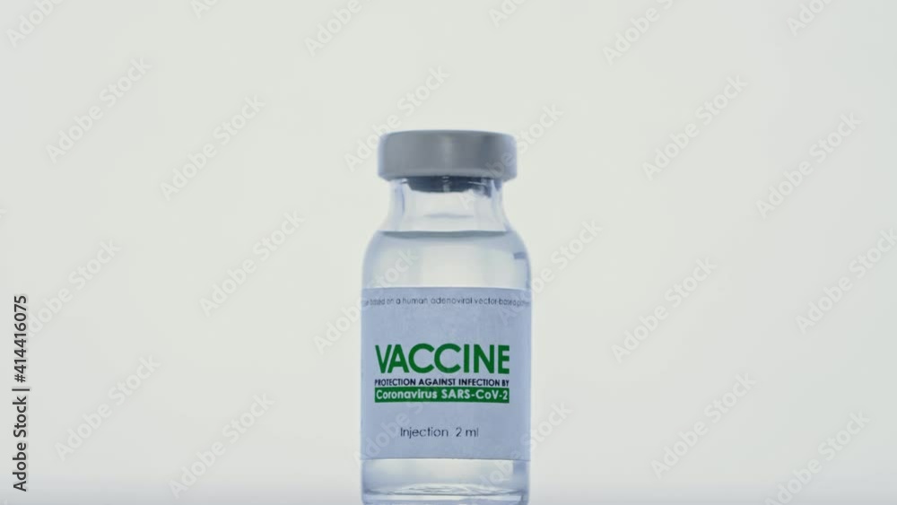 Doctor takes syringe for injection from flask of vaccine for COVID-19 coronavirus cure in research lab. Vaccination concept pandemic. Macro, hand in protective medical glove. Bottle is in foreground Doctor takes syringe for injection from flask of vaccine for COVID-19 coronavirus cure in research lab. Vaccination concept pandemic. Macro, hand in protective medical glove. Bottle is in foreground