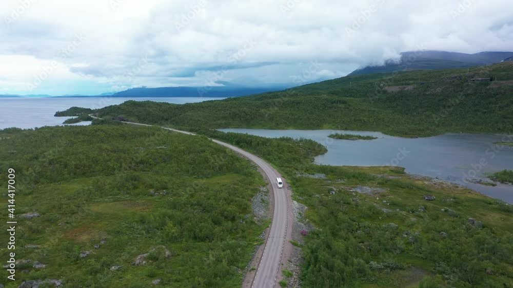 Aerial view following a bus driving at lake Tornetrask, revealing the Lapponian gate, in Sweden - rising, drone shot Aerial view following a bus driving at lake Tornetrask, revealing the Lapponian gate, in Sweden - rising, drone shot