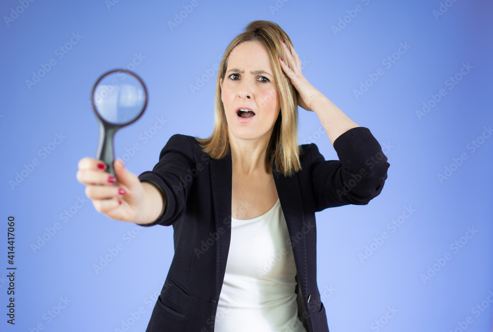 Woman with magnifying glass over purple background
