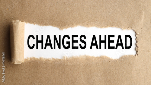 changes ahead. text on white paper over torn paper background.