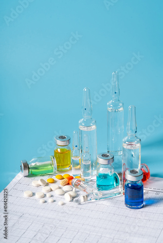 Medical syringes and drugs on blue background