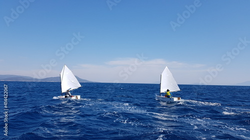 Children sailing with optimist boats