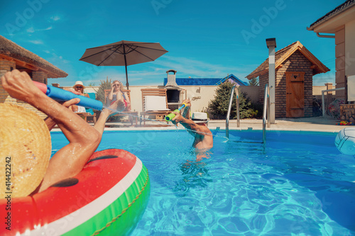 Elderly people having fun splashing water on each other in the swimming pool
