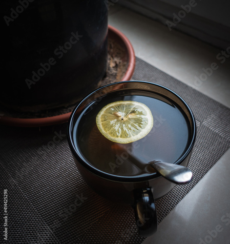 A cup of tea with lemon on the window on a Moscow winter day.