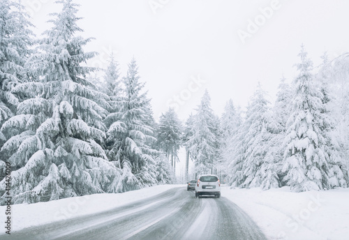 Cars keep their distance on the snow-covered road.Family trip, vacation, adventure. Winter landscape. Driving a car in extreme winter conditions.Travel concept background