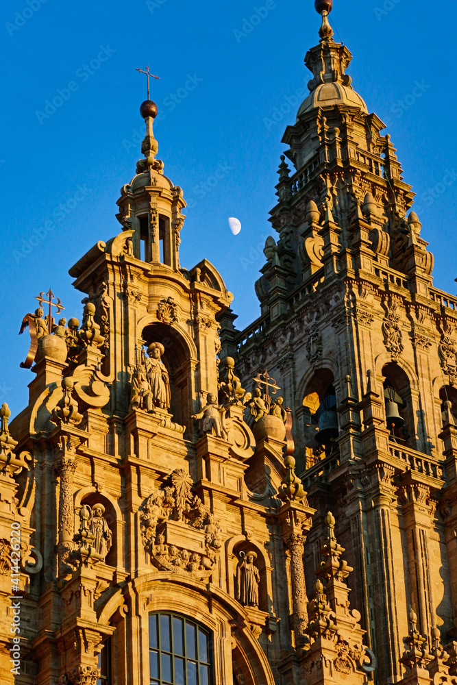 Escultura del Apóstol Santiago en la fachada de la Catedral de Compostela con el campanario al lado y la luna en medio
