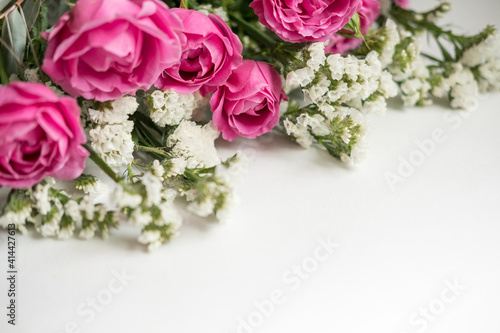 white dried flowers statice and rose raspberry peony on a white background . space for text