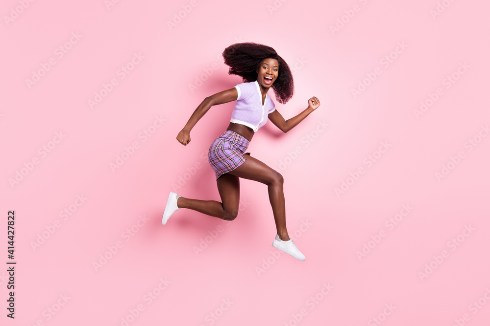Full length body size view of beautiful trendy active cheerful girl jumping running fast action isolated over pink pastel color background