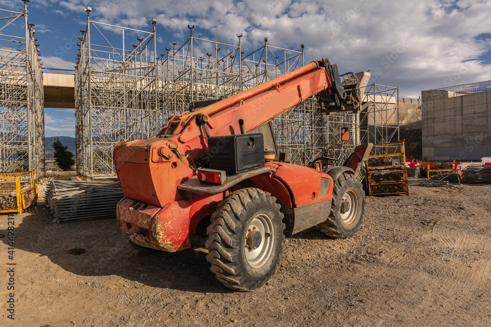 Forklift on a construction site, preparing to raise construction parts Forklift on a construction site, preparing to raise construction parts