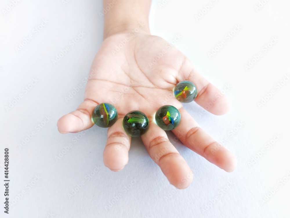 Image of kid's hand and marble isolates on white background Image of kid's hand and marble isolates on white background