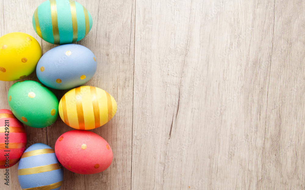 Fototapeta premium Colorful handmade painted easter eggs on a wood background.