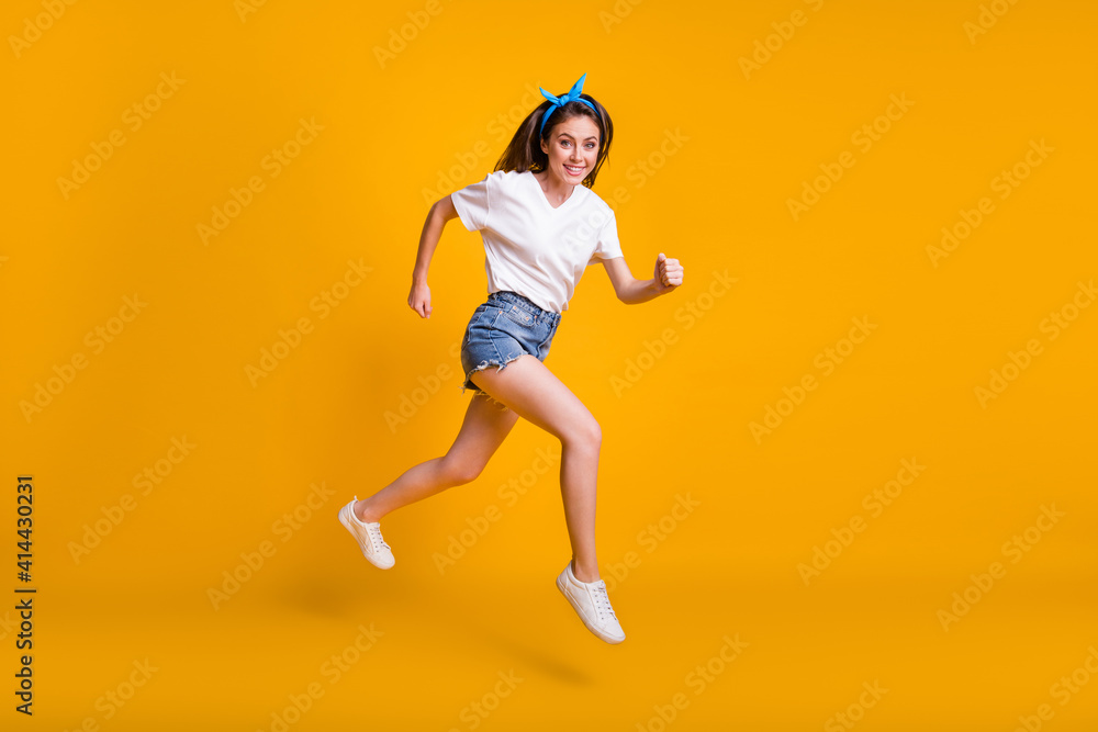 Full length body size photo of girl running fast jumping high hurrying up isolated on vivid yellow color background